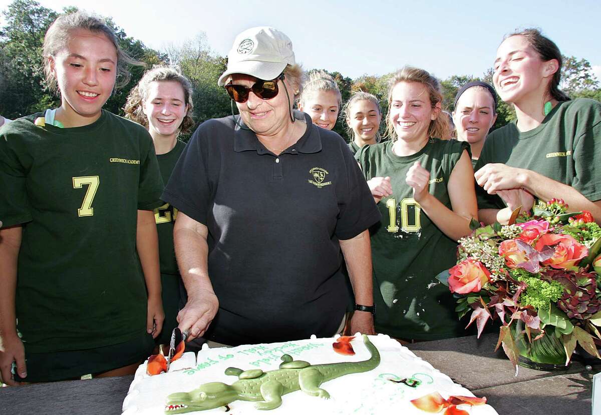 102007, ga fldhockey, ga. Greenwich Academy Field Hockey Coach Angela Tammaro cuts into the cake presented to her at the conclusion of Saturday afternoons game in honor of her induction into the Field Hockey Hall of Fame. David Ames photo. Special David Ames