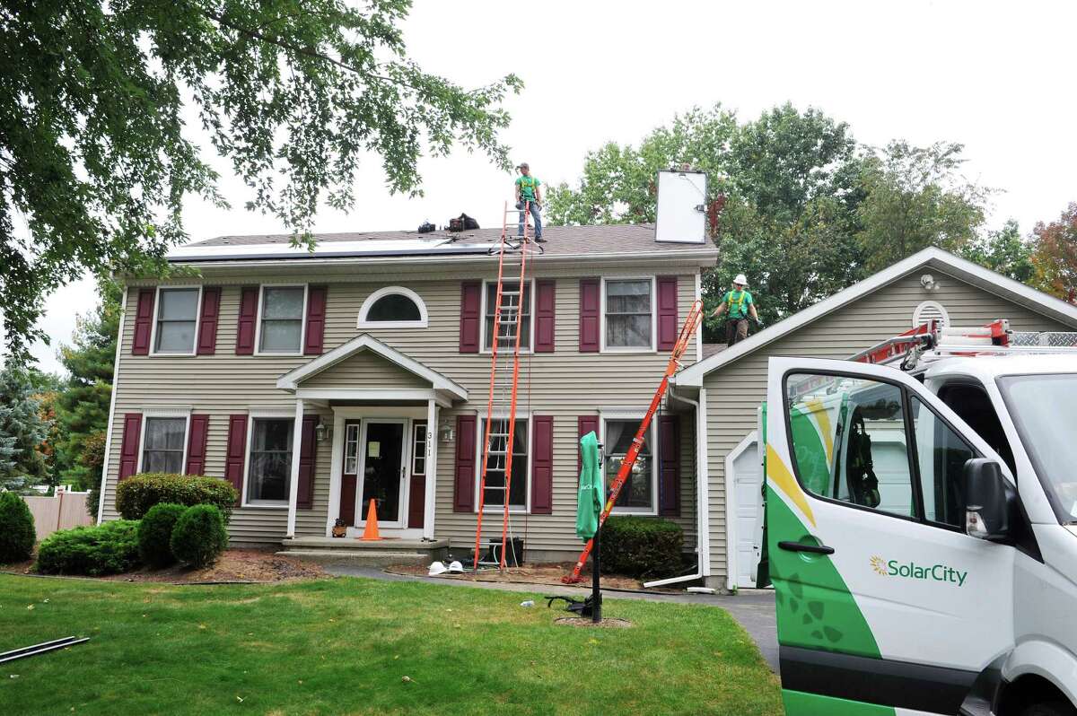 SolarCity installers put in a solar system on the roof of a home on Thursday, Oct. 2, 2014, in Schenectady, N.Y. In total 41 panels were being installed on the home. (Paul Buckowski / Times Union)