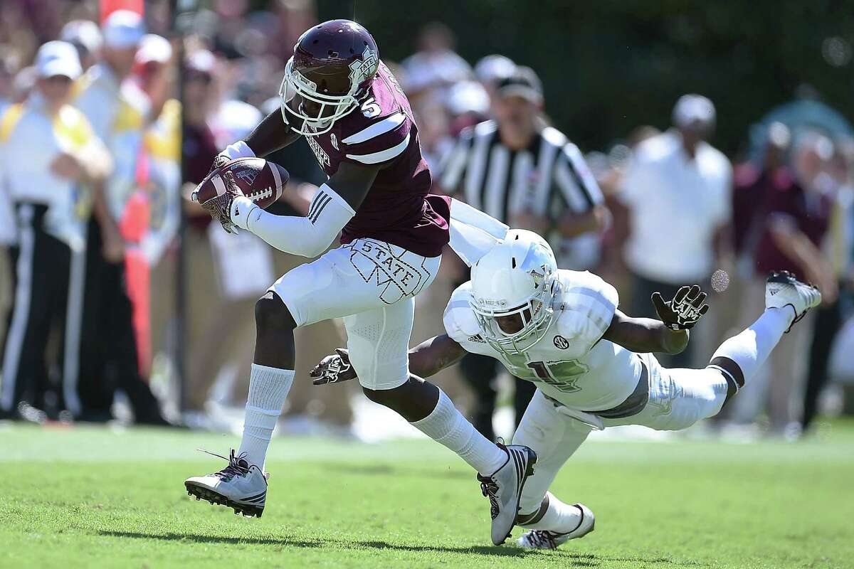 STARKVILLE, MS - OCTOBER 04: Fred Brown #5 of the Mississippi State Bulldogs catches a pass in front of De'Vante Harris #1 of the Texas A&M Aggies during the third quarter of a game at Davis Wade Stadium on October 4, 2014 in Starkville, Mississippi. Mississippi State won the game 48-31.