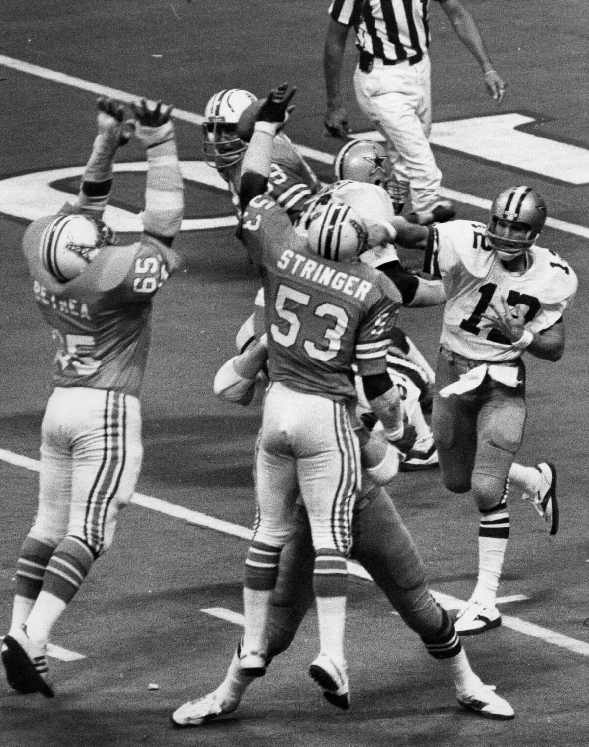 Oilers defenders Elvin Bethea, left, and Art Stringer try to block the passing lanes of Cowboys quarterback Roger Staubach in the 1979 matchup.