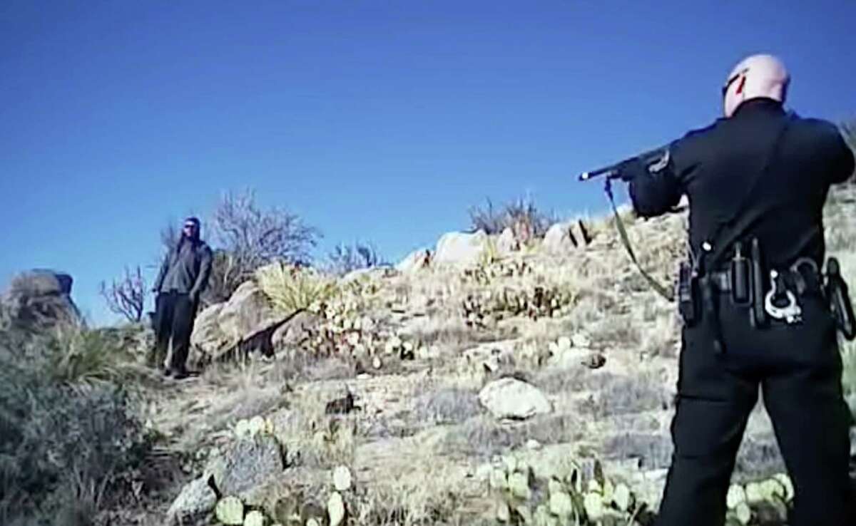 In this file photo taken from a video shot March 16, 2014, James Boyd, 38, left, is shown during a standoff with officers in the Sandia foothills in Albuquerque, N.M., before police fatally shot him. An Albuquerque police officer's comments and behavior before a fatal shooting that sparked a protest and FBI investigation were "completely unacceptable," the city's police chief said Tuesday, Sept. 30, 2014. In an interview with The Associated Press, Chief Gorden Eden said officer Keith Sandy violated department policy when he used profanity to describe a 38-year-old mentally ill homeless man.
