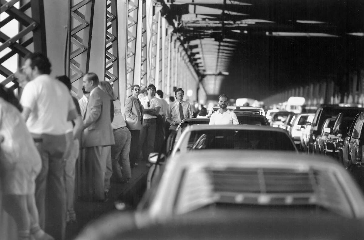 October 17, 1989: People mill around their cars after being stopped on the Bay Bridge after the Loma Prieta earthquake.