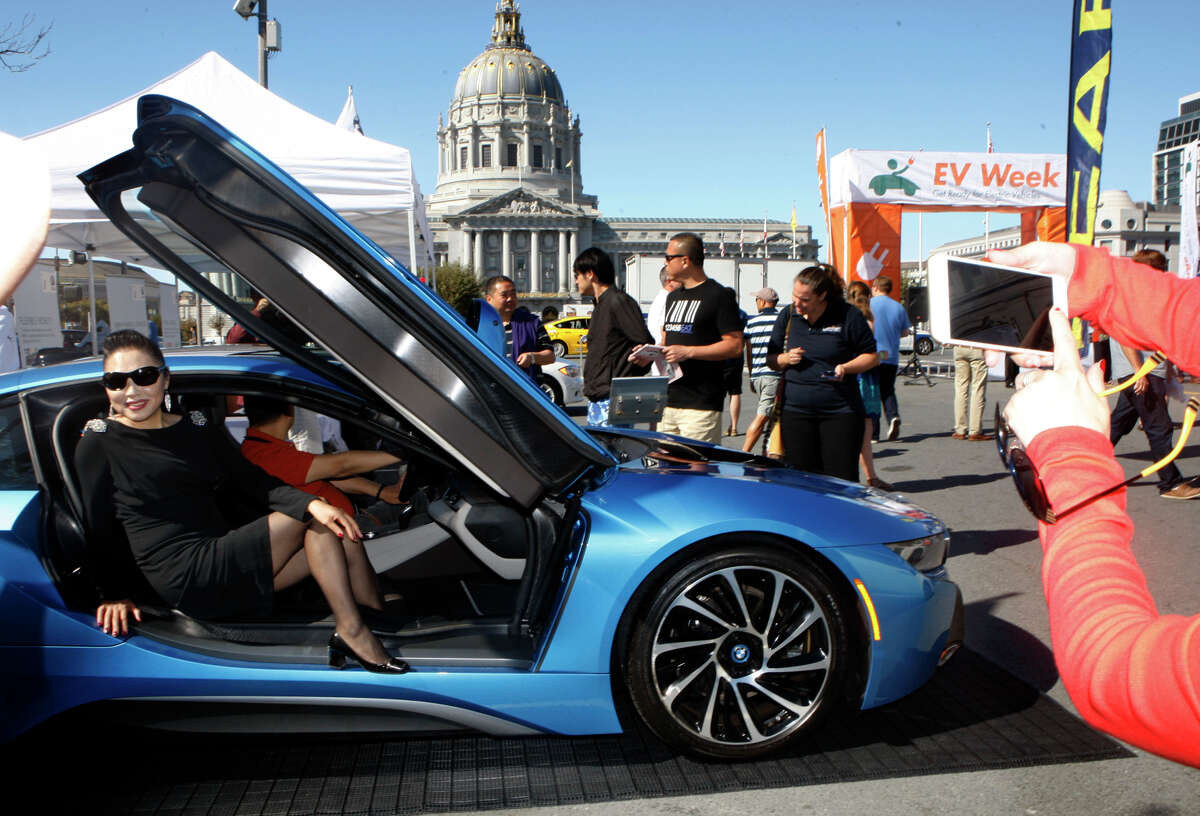 Tourists take pictures in the 2014 BMW i8, an electric sports car seen at the annual Charge Across Town in the plaza between the SF main library and Asian museum in San Francisco, Calif., on Monday, October 6, 2014.