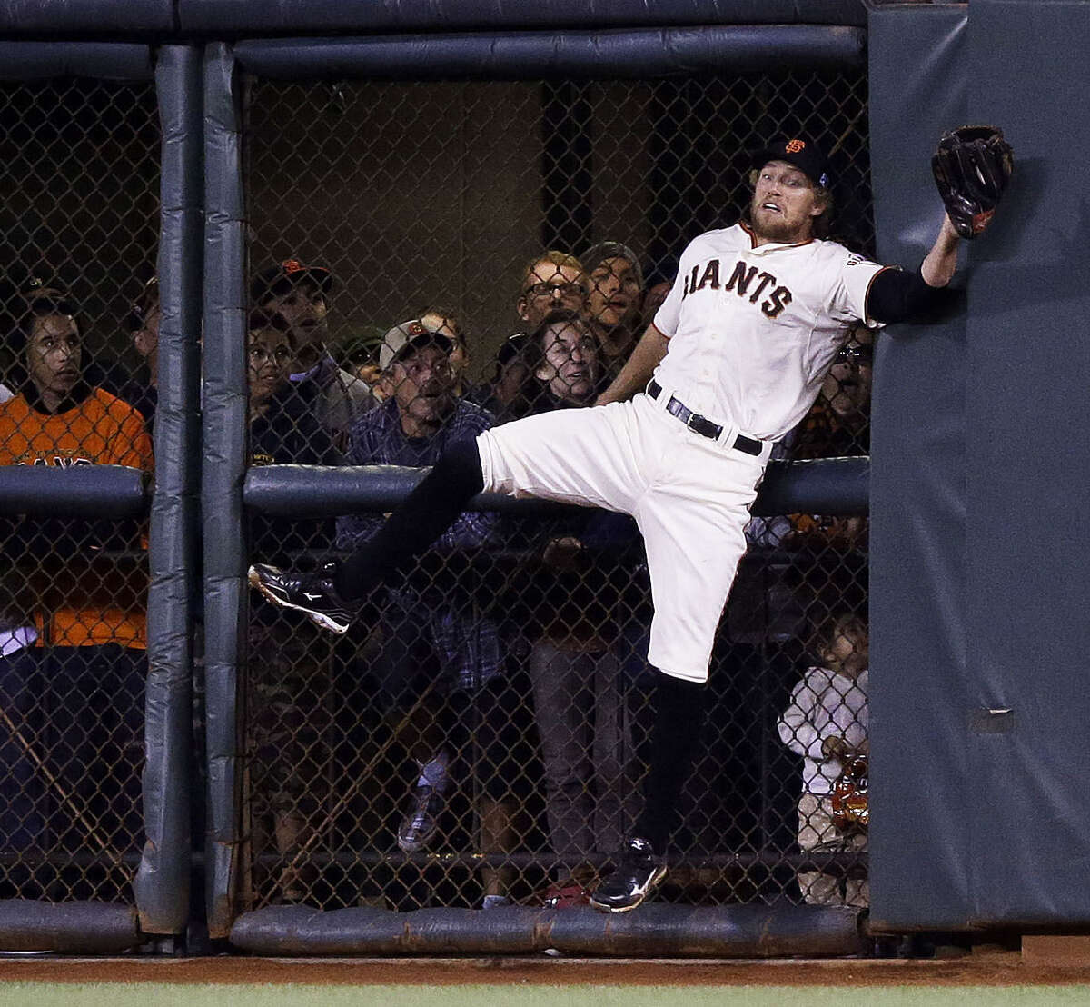 The Giants' Hunter Pence makes a difficult catch against the wall in the sixth inning as fans look on during San Francisco's series-clinching victory over the Nationals on Tuesday night at AT&T Park.