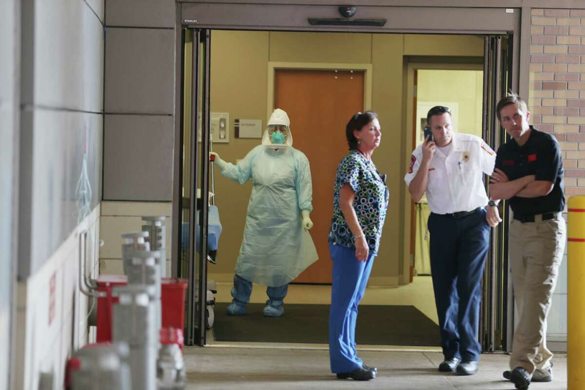 When is Ebola contagious? Only when someone is showing symptoms, which can start with vague symptoms including a fever, flu-like body aches and abdominal pain, and then vomiting and diarrhea. Health care workers wait for the arrival of a possible Ebola patient at the Texas Health Presbyterian Hospital on October 8, 2014 in Dallas, Texas. Thomas Eric Duncan, the first confirmed Ebola virus patient in the U.S., died earlier today.