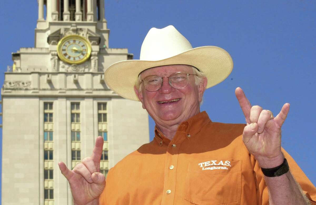 Former Judge Harley Clark flashes the "Hook 'Em Horns" in front of the Tower at UT Austin in 2001.﻿ Clark created the hand sign in 1955 at a pep rally.