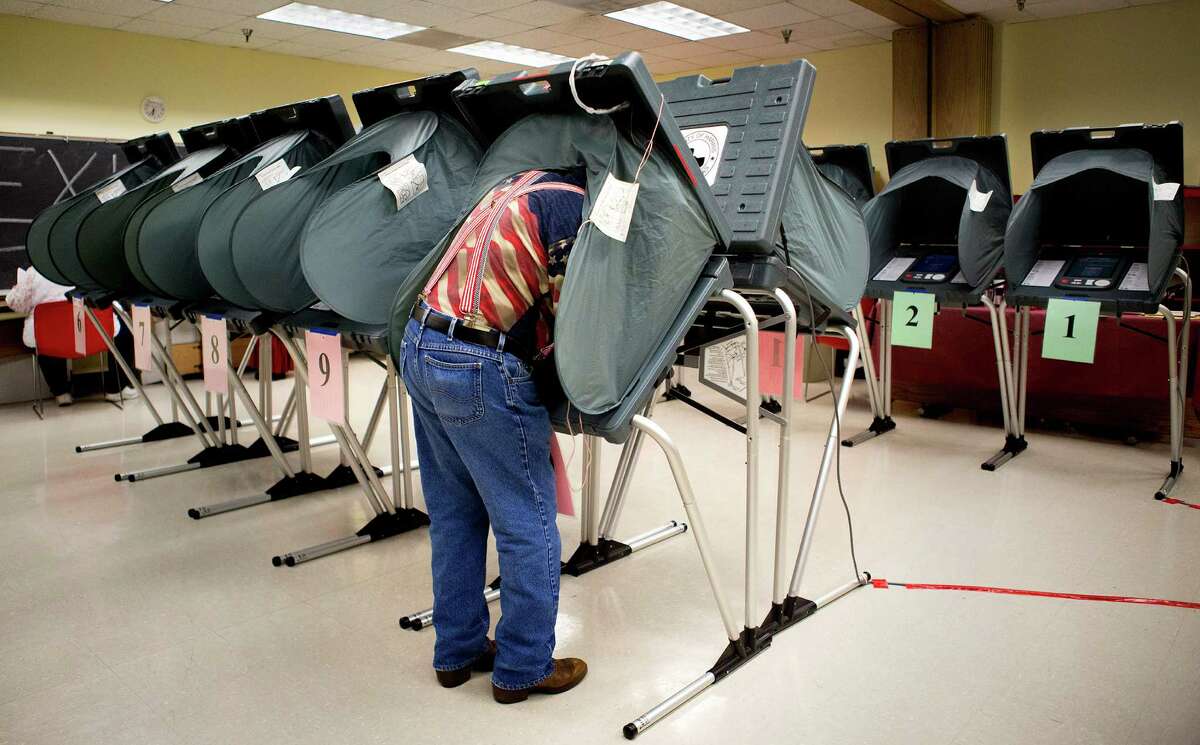 Election Clerk Richard DeLosSantos prepares voting booths at the Metropolitan Multi-Services Center, Tuesday, May 27, 2014, in Houston. (Cody Duty / Houston Chronicle)