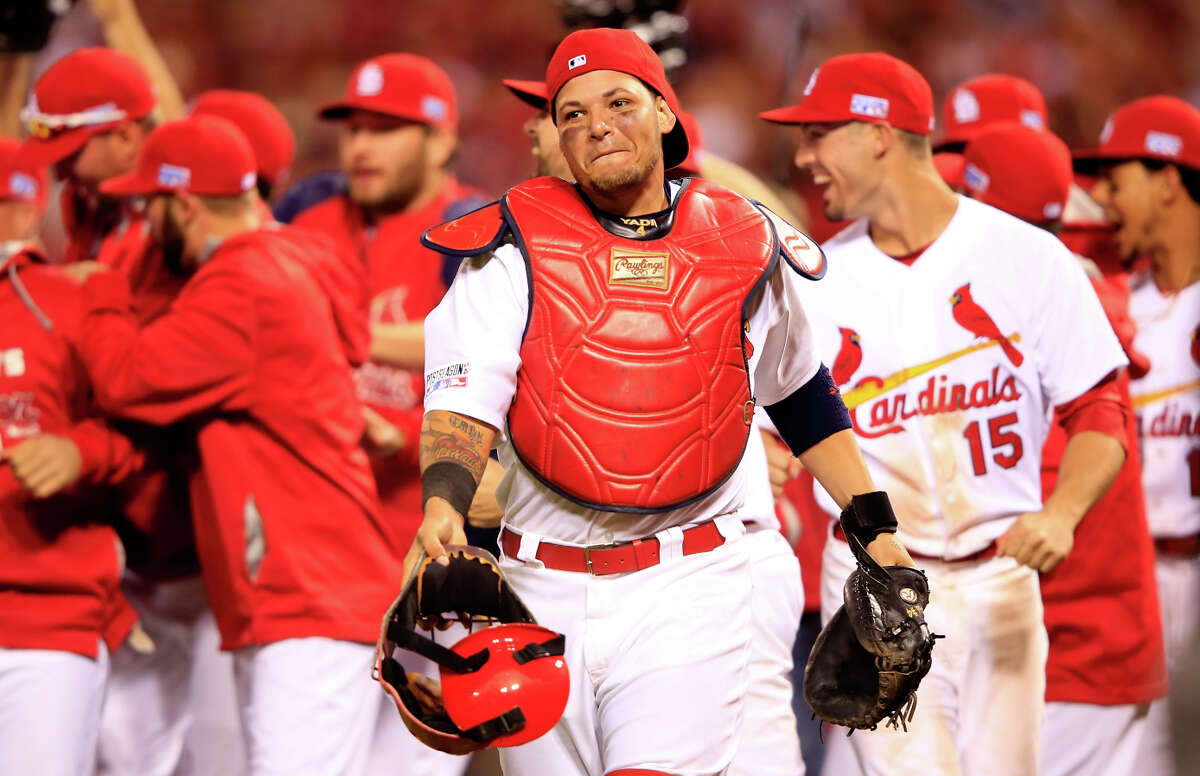 The Cardinals’ Yadier Molina (center) has won the NL catching Gold Glove for the past six years and, like the Giants’ Buster Posey, has played for two World Series winners.