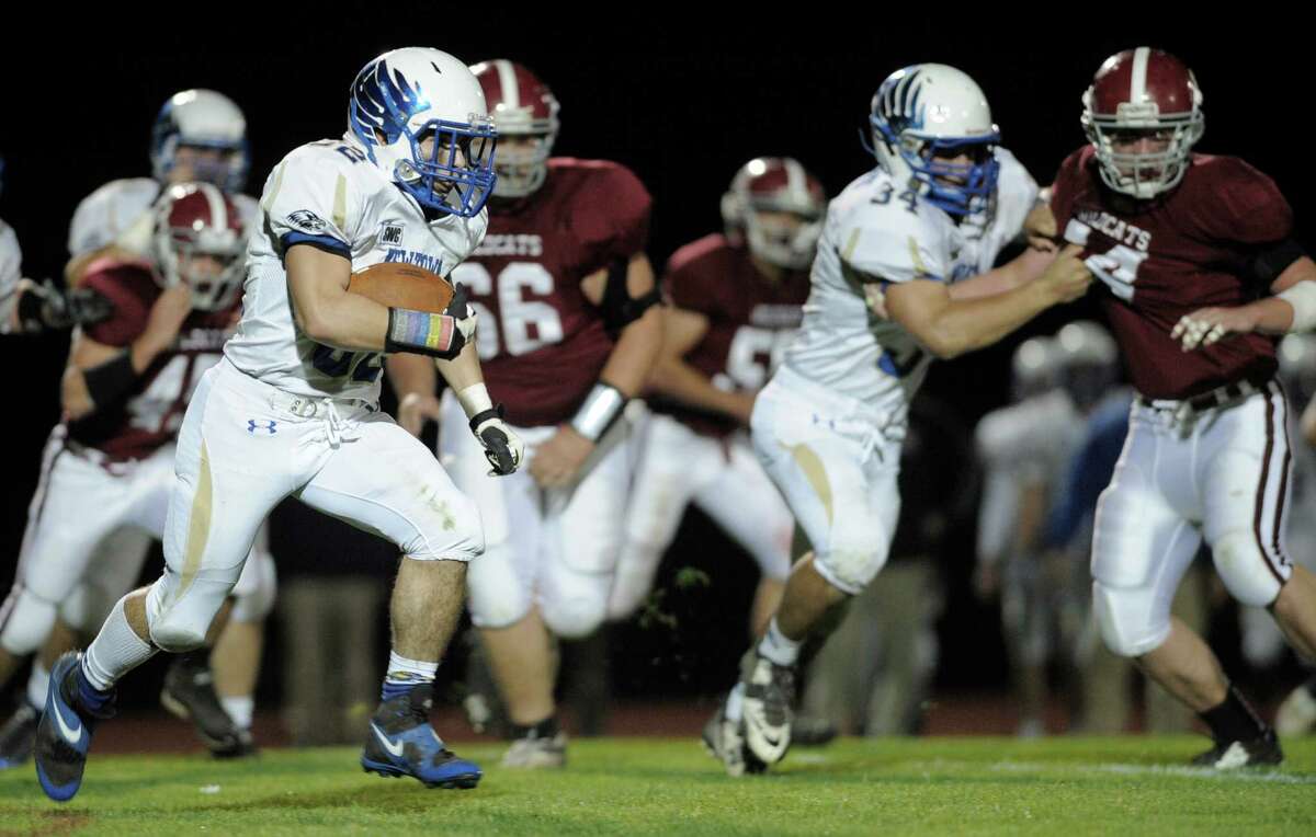 Newtown's Jaret Devellis (32) sweeps around the right side during Friday nights football game between Newtown and Bethel High School's, on October 10, 2014, in Bethel, Conn.