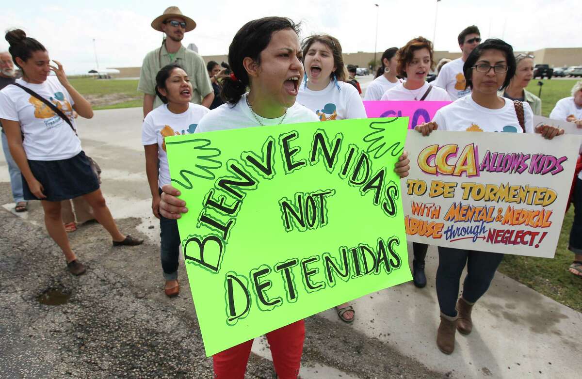 Andrea Ortiz of Austin (center) joins others in a chant for justice for immigrants at the Karnes County Residential Center near Karnes City on Saturday, Oct. 11, 2014. About 100 protesters gathered to demand the closing of the facility and for the release of immigrants detained at the facility.