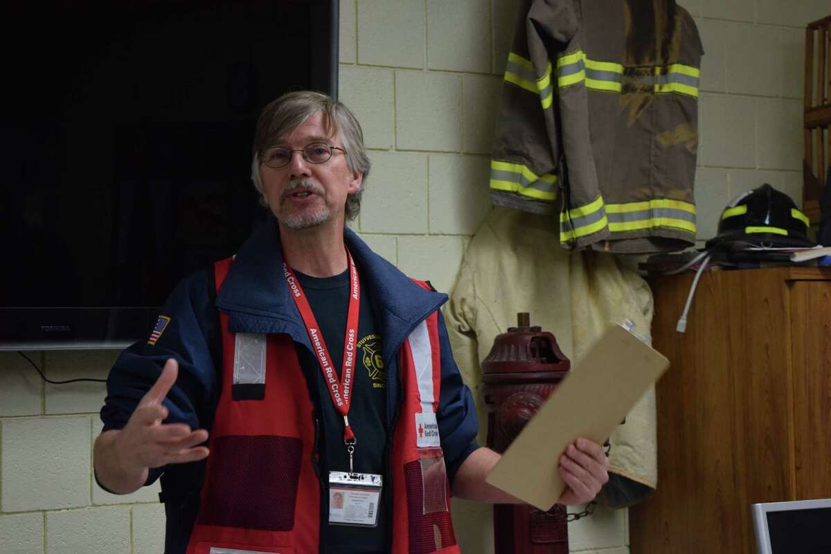 Ed Roosa, the disaster program manager of emergency services for the American Red Cross, reviews Saturday's protocol for fire alarm installation.
