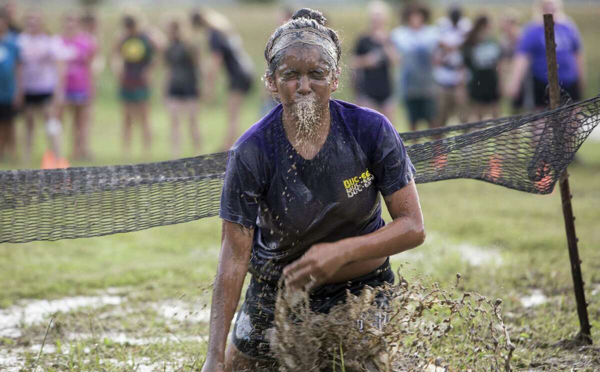 A student spits out water after clearing an obstacle during the NEISD Agriscience Magnet Program's Ag Olympics.