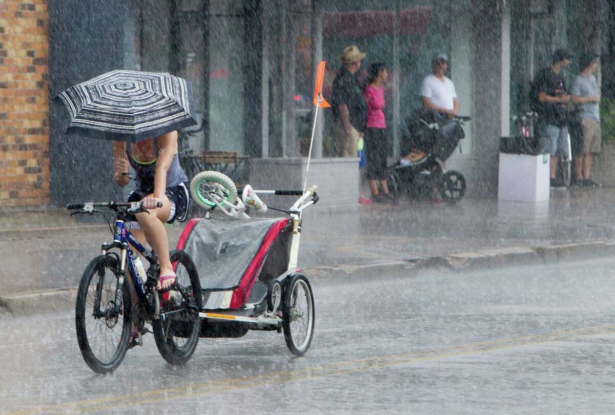 A downpour on Sunday only temporarily halted activity along 19th Street in the Heights at Sunday Streets HTX. Mayor Annise Parker's initiative seeks to encourage a healthier, more mobile lifestyle.﻿