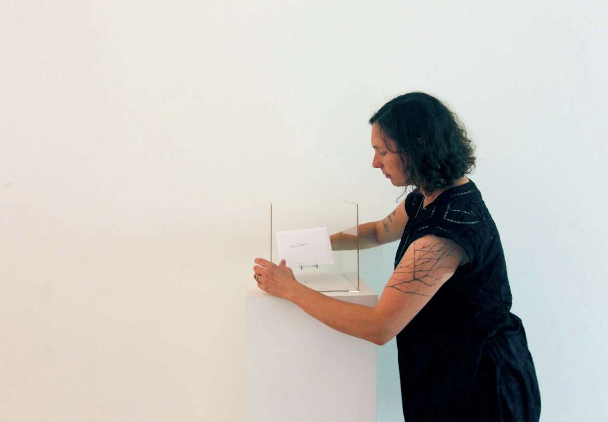 Jessamyn Lovell places a personal letter into a display case for her photo exhibit at the SF Camerawork gallery.