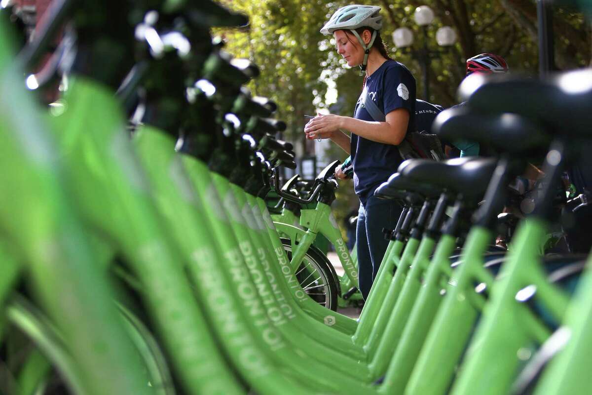 A rider participating in an inaugural ride prepares to check out a bike from Pronto Cycle Share as the program is launched in Seattle on Monday, October 13, 2014. The program will have 500 bicycles available for rent at 50 stations mostly in the core of Seattle.