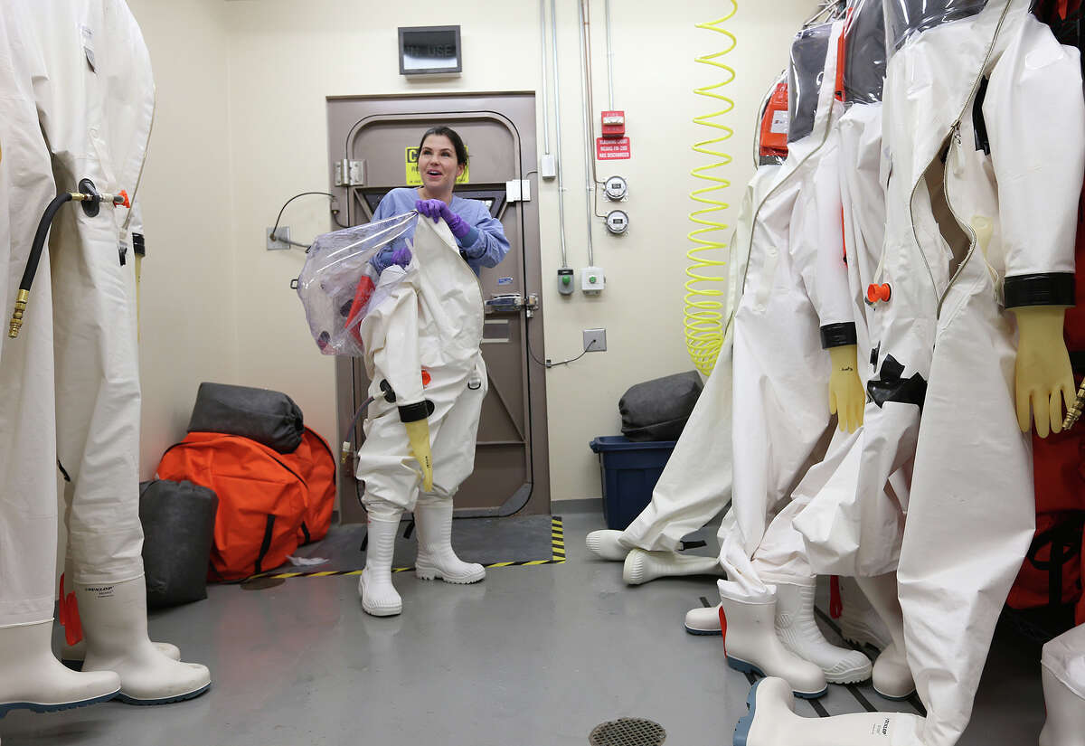 Researcher Dr. Gabi Worwa, DVM, removes her suit after working the with the Ebola virus in the Biosafety Level-4 lab of the Texas Biomedical Research Institute, Tuesday, Oct. 14, 2014. The institute has been working on an Ebola vaccine for the past 10 years.