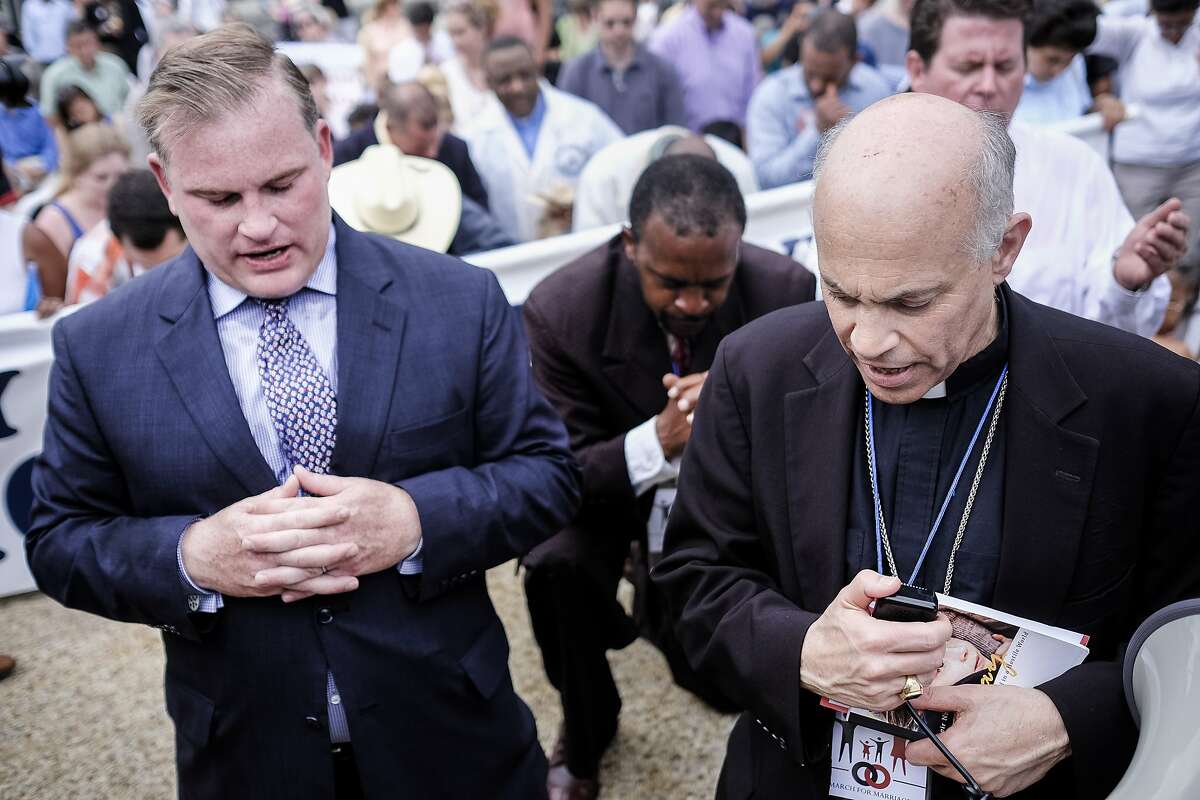 San Francisco Archbishop Salvatore Cordileone, right, and Brian Brown, left, march organizer and president of the National Organization of Marriage, kneel to pray as participants in the March for Marriage gather across from the Supreme Court in Washington, DC on June 19, 2014. Speakers at the rally and march promoted the definition of marriage as between a man and a woman, and pushed back against the notion that public opinion is heavily in favor of revoking restrictions against gay marriage. (Photo by T.J. Kirkpatrick/Special to The Chronicle)