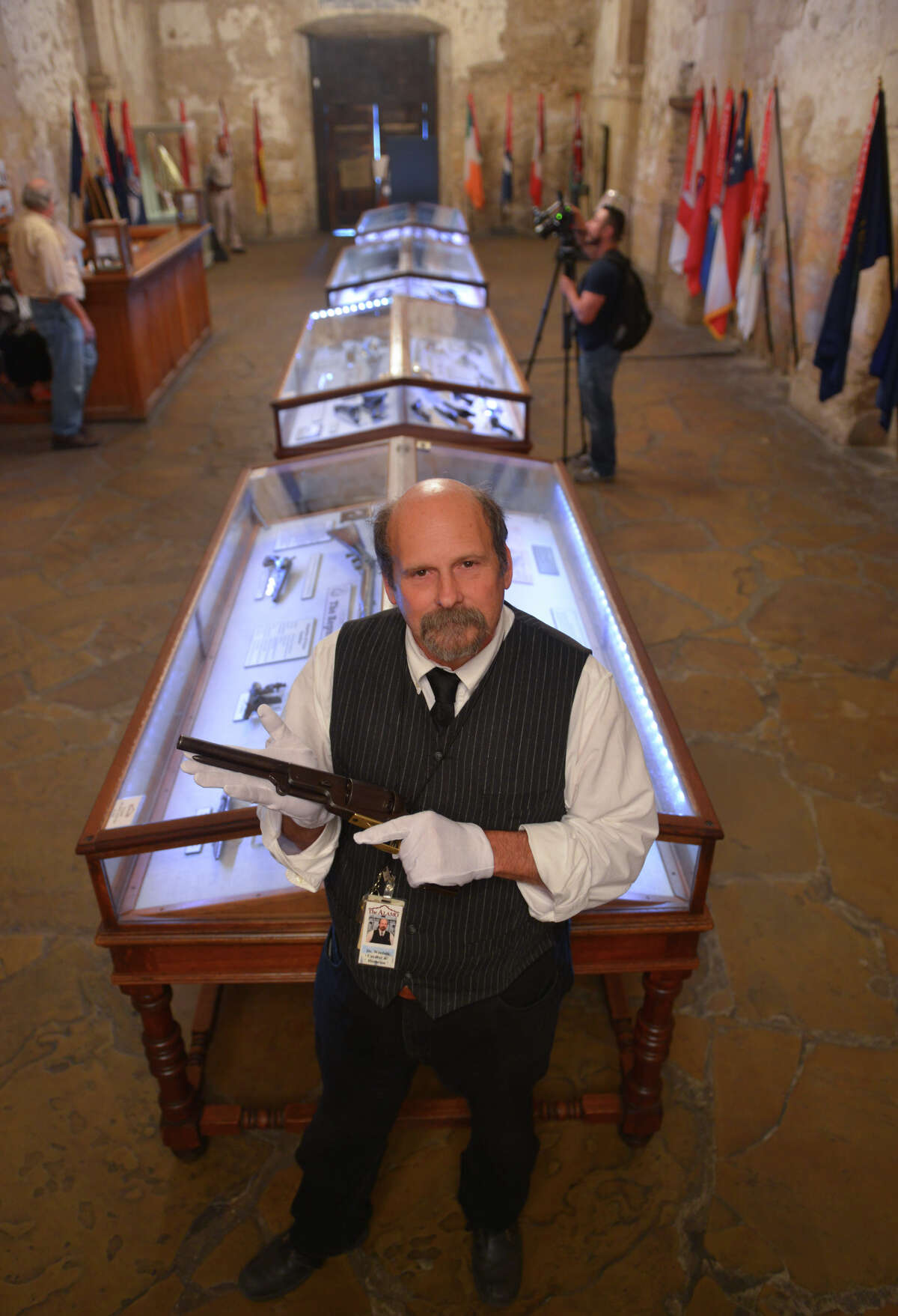 Alamo Historian and Curator Dr. Bruce Winders displays the "Firearms of the Texas Frontier, Flintlocks to Cartridge (1836-1876) which will be on display in the Alamo Shrine through April 15, 2015. He is holding a Colt Walker pistol.