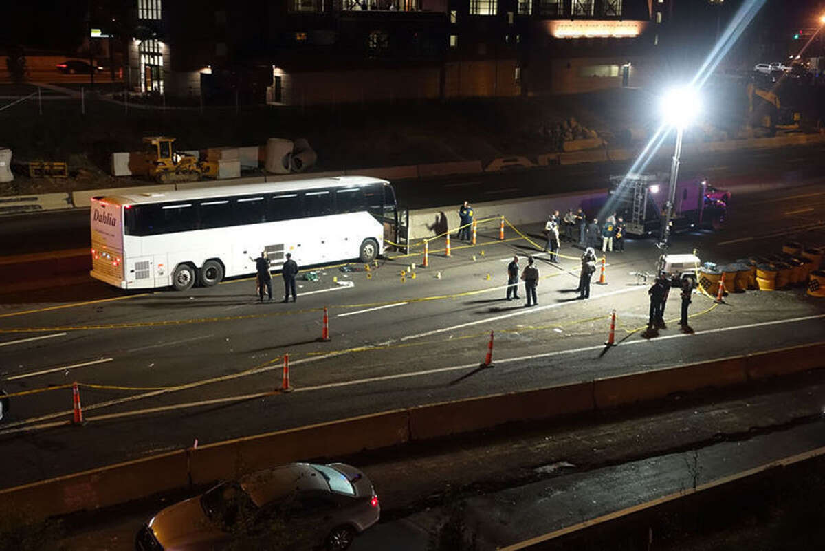 Law enforcement investigate the scene of a stabbing aboard a tour bus late Tuesday, Oct. 14, 2014 in Norwalk, Conn. A man who stabbed passengers on the casino-bound tour bus on Interstate 95 was fatally shot by state police, officials said Wednesday. The unidentified man began attacking passengers around 10 p.m., state police spokesman Lt. Paul Vance said. The bus driver flagged down a trooper at a construction site. The suspect acted aggressively toward the trooper and was shot when he refused to drop his weapon.