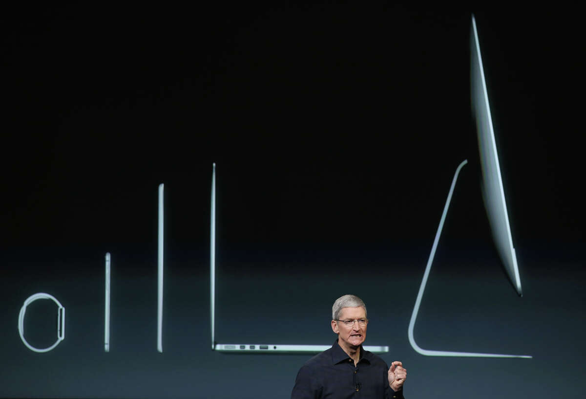 With Apple products shown behind him, CEO Tim Cook speaks during an event introducing new iPads.
