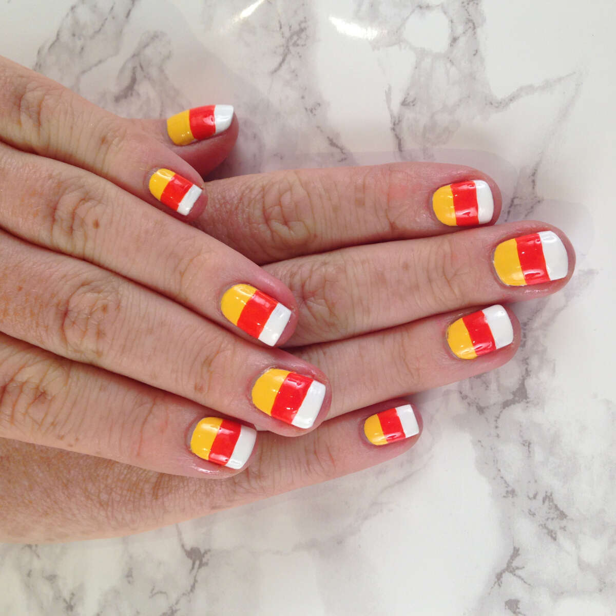 Candy corn-inspired Halloween nail art by TopCoat nail artist Taylor Watson of SF Party Nails: White Matter by Formula X Nail Polish, Monarch by RGB Cosmetics, Pimms by Butter London.