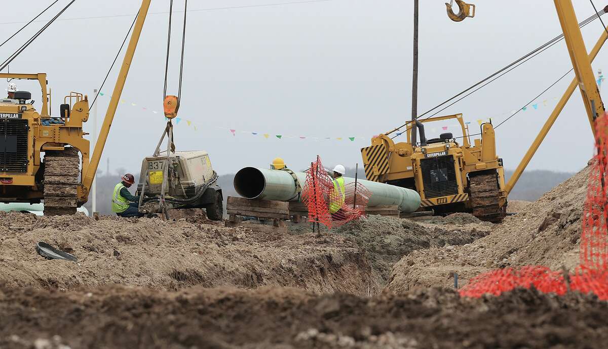 Workers lay pipe in Karnes County. As of early 2013, more than 1,000 wells had been drilled in the county and more than 2,000 miles of pipeline had been added since 2010.