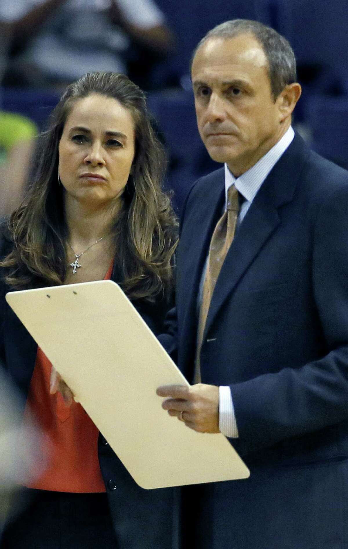 Spurs assistant coach Ettore Messina (right), who took Gregg Popovich's place Thursday, and assistant Becky Hammon discuss a play during the first half against the Suns.