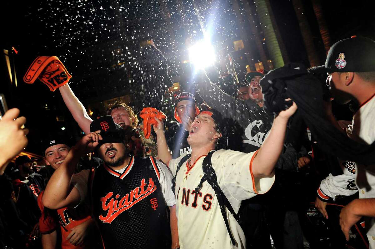 Champagne flies as fans celebrate outside AT&T Park as the San Francisco Giants defeated the St. Louis Cardinals to win the NLCS, in San Francisco, CA, on Thursday, Oct. 16, 2014.