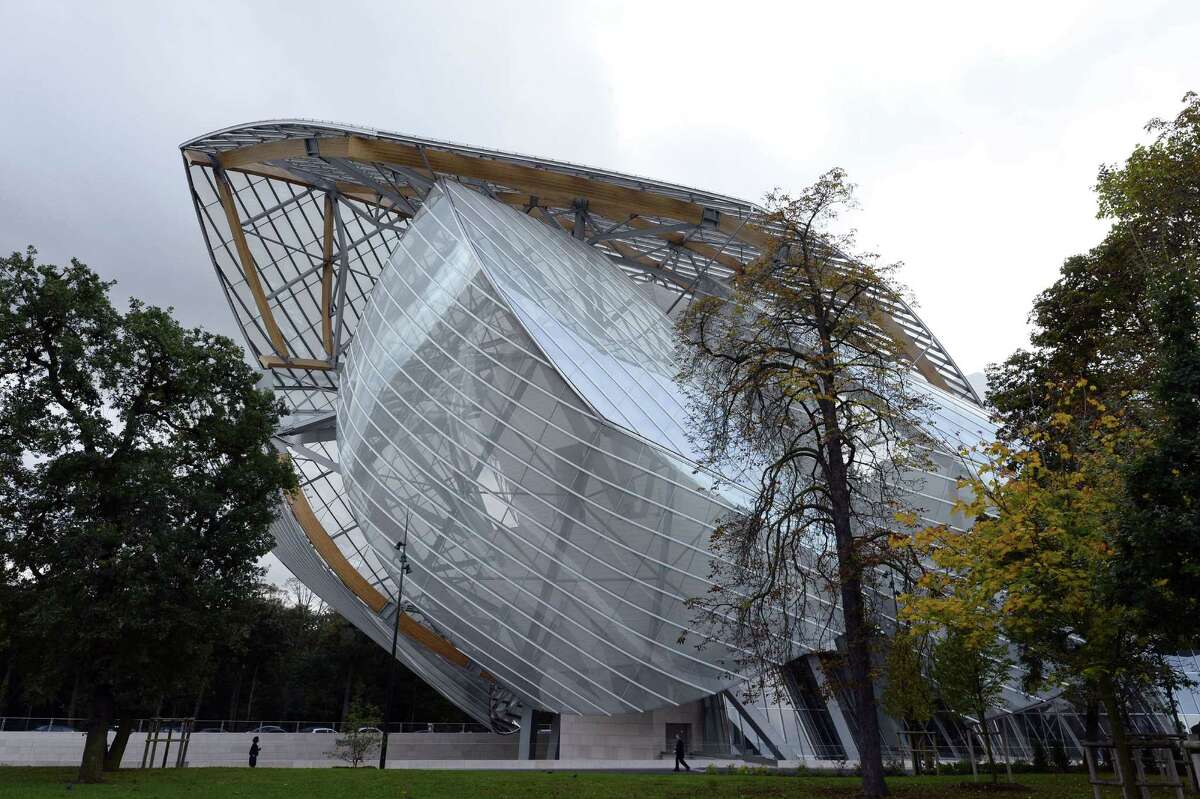 People walk in front of the Louis Vuitton Foundation designed by Canadian-American architect Frank Gehry in the Bois de Boulogne in Paris.