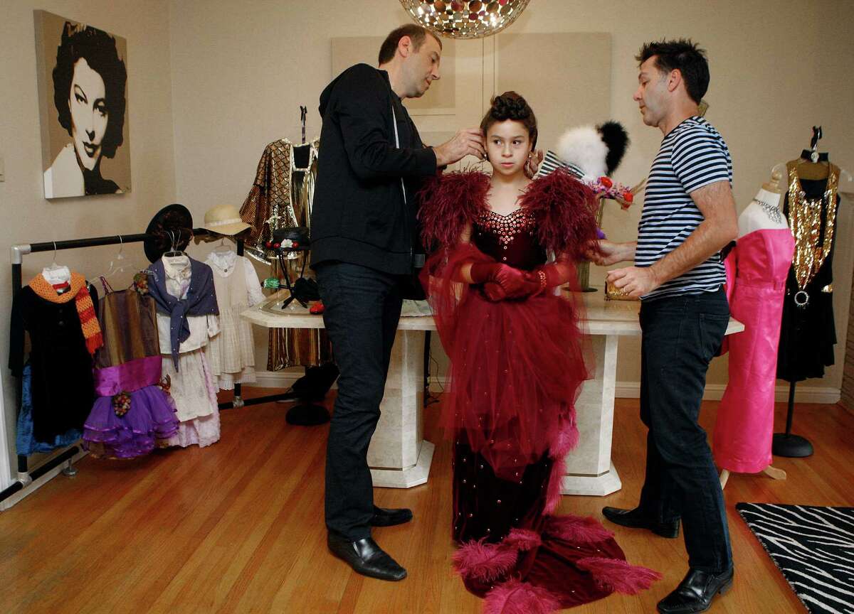 Frank Silletti (left) and Sonny Vukic (right) help dress Ava Vukic (middle) into the Scarlett O'Hara halloween costume at home in San Francisco.