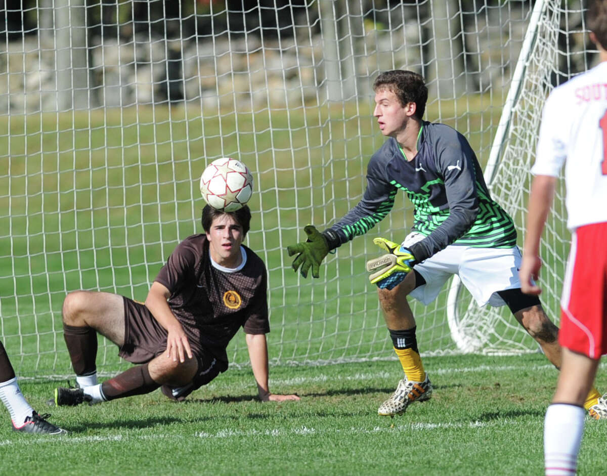 At right, Brunswick goal keeper Ben Rogers collects the ball after making a save as teammate, Thomas Errichetti (#13), defends, during the high school soccer match between Brunswick School and South Kent at Brunswick in Greenwich, Conn., Friday afternoon, Oct. 17, 2014.