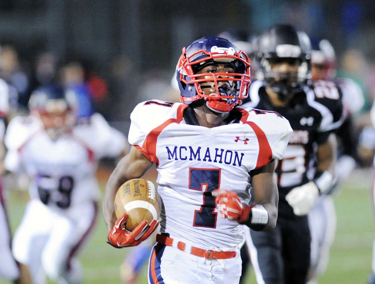 At center, Kentrell Snider (#7) of Brien McMahon scores his first third quarter rushing touchdown as he gets past Stamford's Darwin Leon (#23), at right, during the high school football game between Stamford High School and Brien McMahon High School at Stamford, Friday night, Oct. 17, 2014. Brien McMahon defeated Stamford, 49-21.