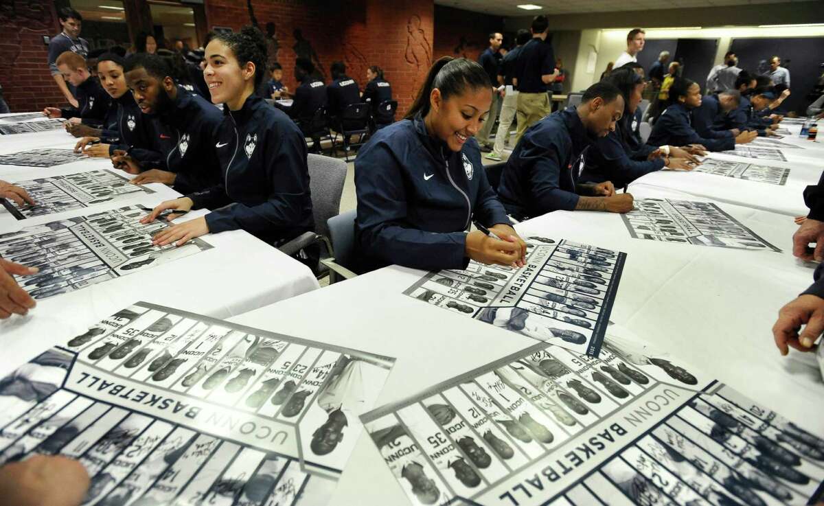 Connecticut's Kia Nurse, left center, and Kaleena Mosqueda-Lewis, right center, sign autographs during the women's and men's NCAA college basketball teams' First Night event, Friday, Oct. 17, 2014, in Storrs, Conn. (AP Photo/Jessica Hill)