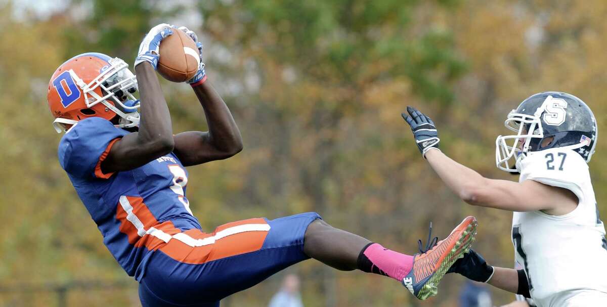 Danbury's Pierre Moudourou (9) comes down with the ball near the goal line while being defended by Staples Jack Griffin (27) during the Staples and Danbury High School boys football game on Saturday, October, 18, 2014, in Danbury, Conn.