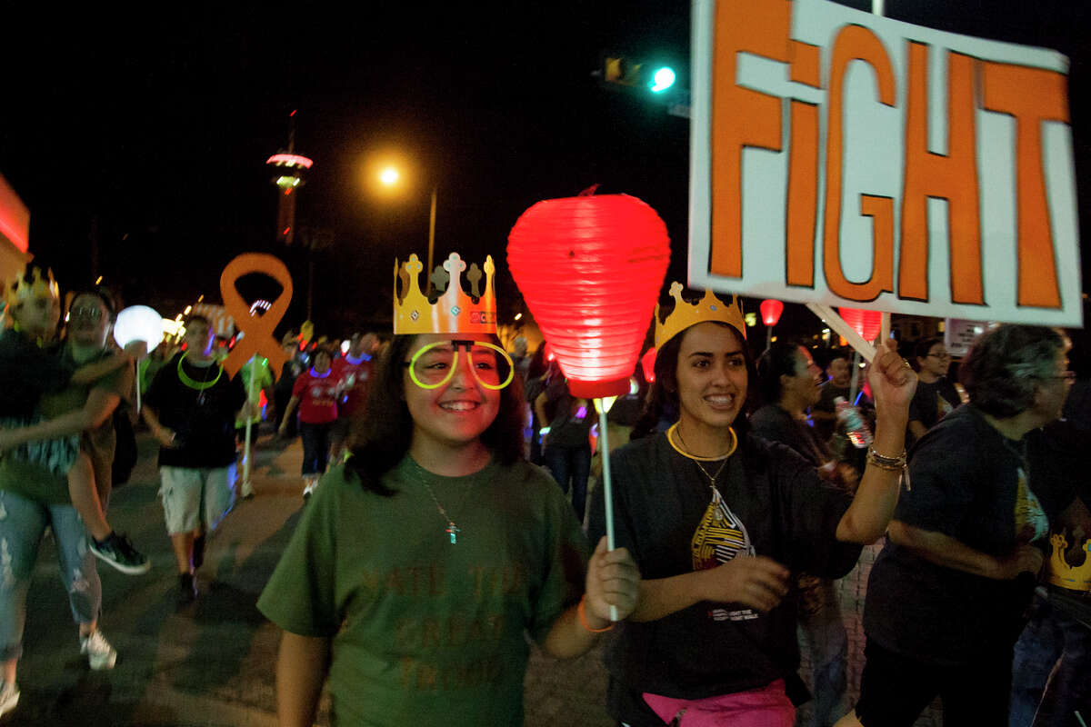 Elizabeth Garcia, 10, and Caitlin Guarnero, 17, walk during the Light The Night Walk fundraising campaign of the Leukemia and Lymphoma Society Saturday October 18, 2014 at La Villita. The money raised by the campaign help fund advanced therapies.
