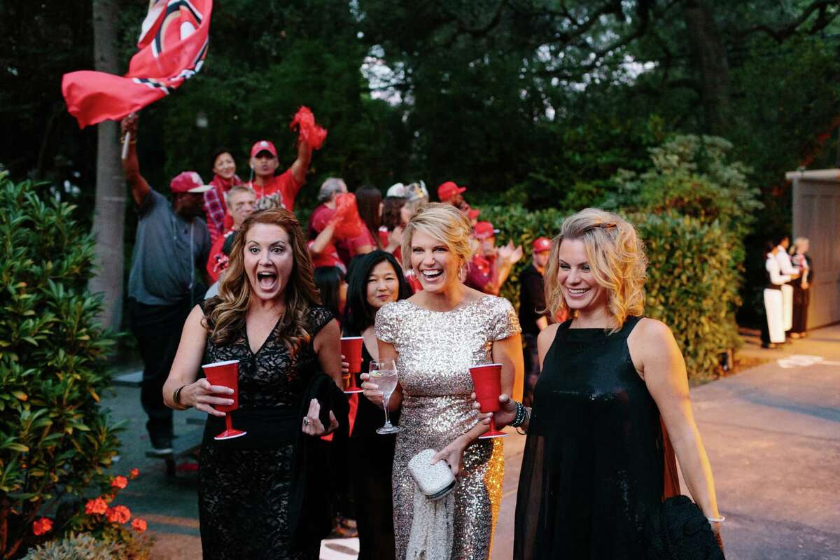 No players in sight — but “fans” cheered Sarah Harbaugh (center, in gold), the wife of 49ers head coach Jim Harbaugh, as she made an entrance with Susan Hanse (left) and friend Nancy Delis (right) at the Superball benefit for the 49ers Academy at Jillian Manus' home in Atherton, Calif., Friday, September 26, 2014.
