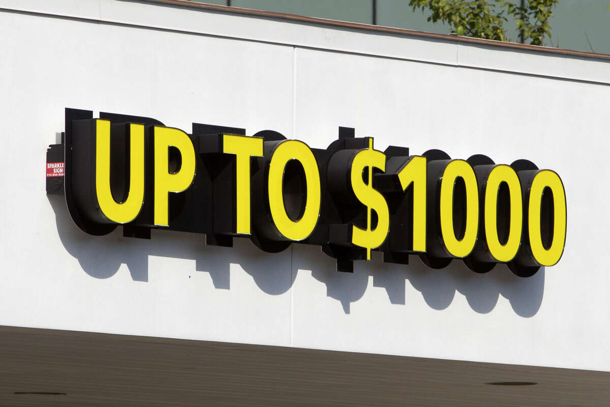 Signs for loan up to $1000 are seen at the Power Finance Payday Loans building on Monday, Oct. 20, 2014, in Houston .