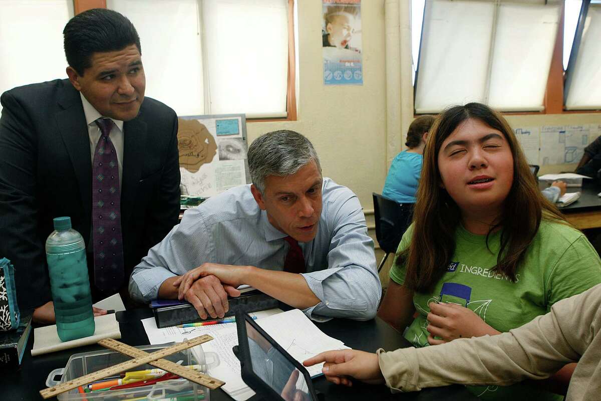 U.S. secretary of education Arne Duncan (middle) teaches Natalie Wohlstein (right), 13 years old, about exterior angles in an eighth grade math class at Roosevelt Middle School in San Francisco, Calif., with SFUSD superintendent Richard A. Carranza (left) on Tuesday, October 21, 2014.