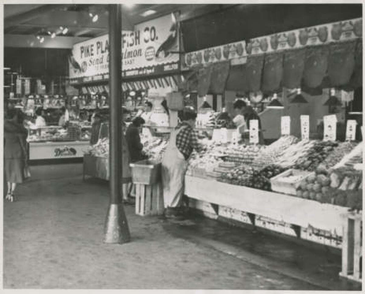 Pike Place Fish Company and produce stalls at Pike Place Market, February 1952.