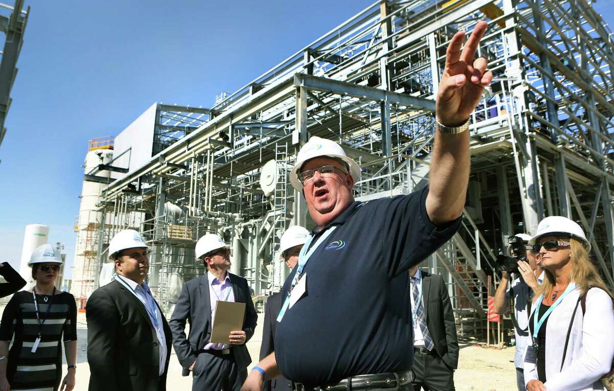 Plant manager Jeff Smith, center, gives a tour of the Capitol SkyMine plant in San Antonio, which will capture 15 percent of the carbon dioxide emissions from the adjacent Capitol Aggregates cement plant.
