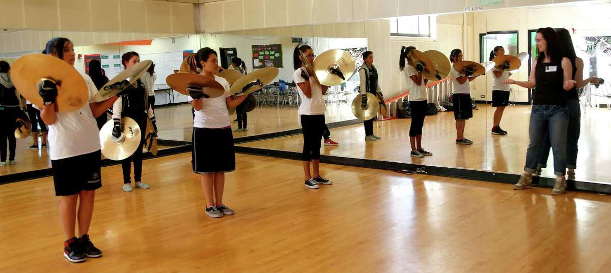 Choreographer Lydia Hance works with members of the Stephen F. Austin High School Marching Band in their band hall.