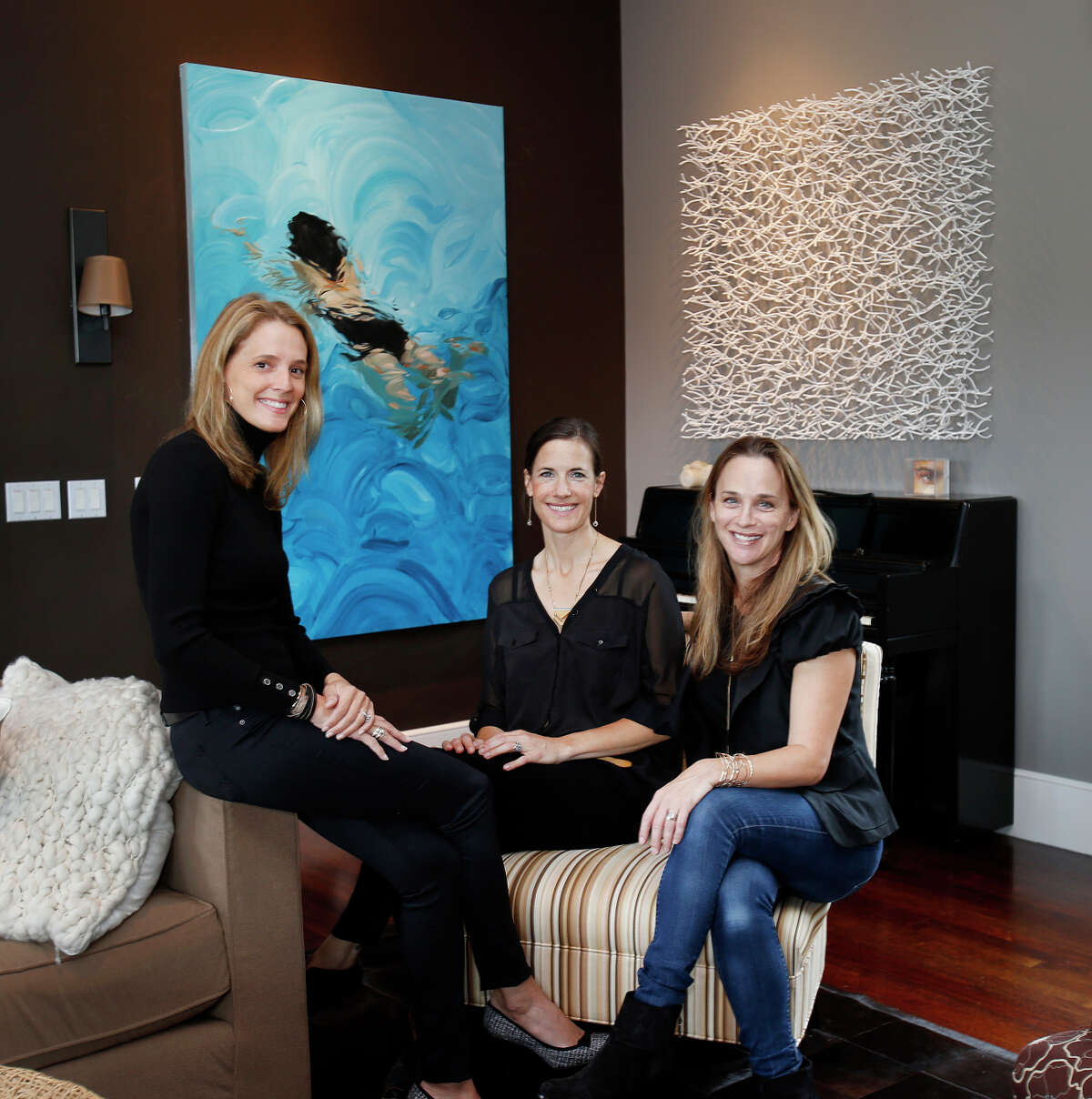 Art dealer Stephanie Breitbard (right) and colleagues Svea Lin Soll (center) and Eve Simon in Breitbard’s Mill Valley home, which is also an art gallery. In the background are a painting of a swimmer by Benjamin Anderson and a sculpture by Matt Devine.