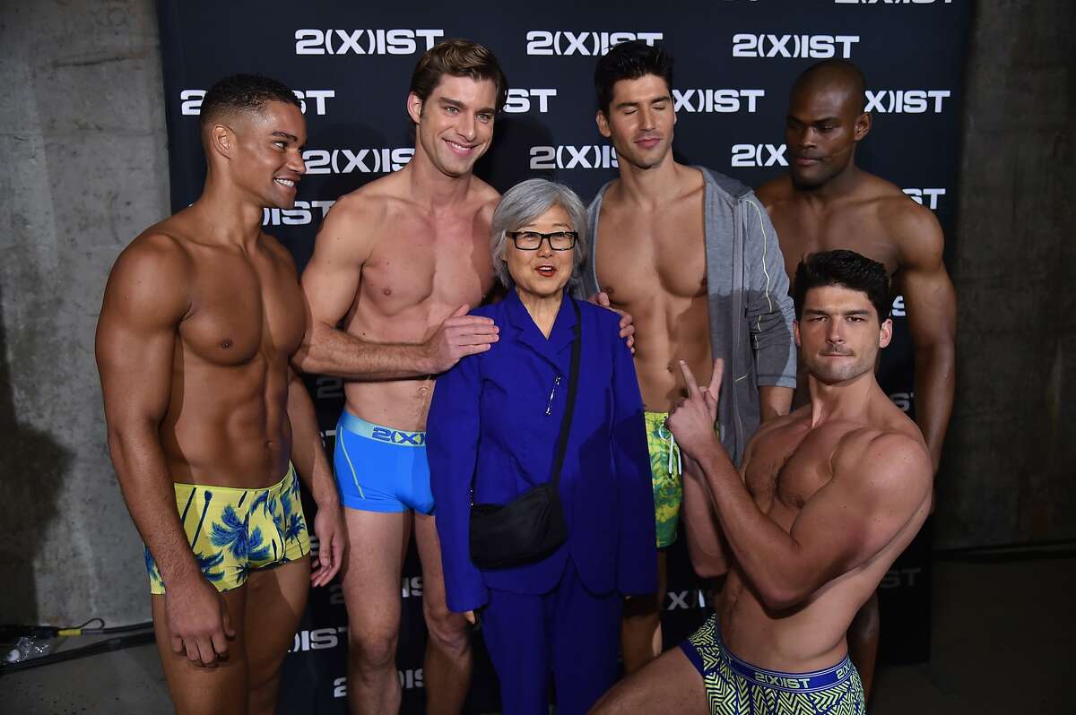 DREAMS DO COME TRUE! A guest poses with hunky models backstage during 2(X)IST Spring/Summer 2015 Runway Show in New York City.