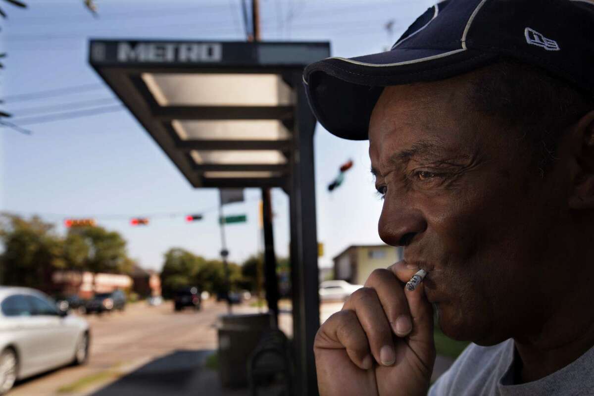 Larry Moore smokes while waiting for ﻿a bus ﻿at Richmond ﻿and Hazard on Wednesday﻿. "I can understand why people wouldn't like the smoke," Moore said. Metro could expand its smoking ban to uncovered bus stops and park and ride lots in the new code. ﻿