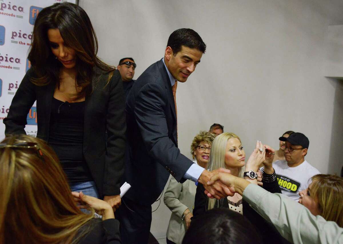 Actress and producer Eva Longoria, left, joins Nicholas LaHood, Democratic candidate for district attorney, right, onstage at Plaza Pica Pica on the Southside on Wednesday, Oct. 22, 2014.
