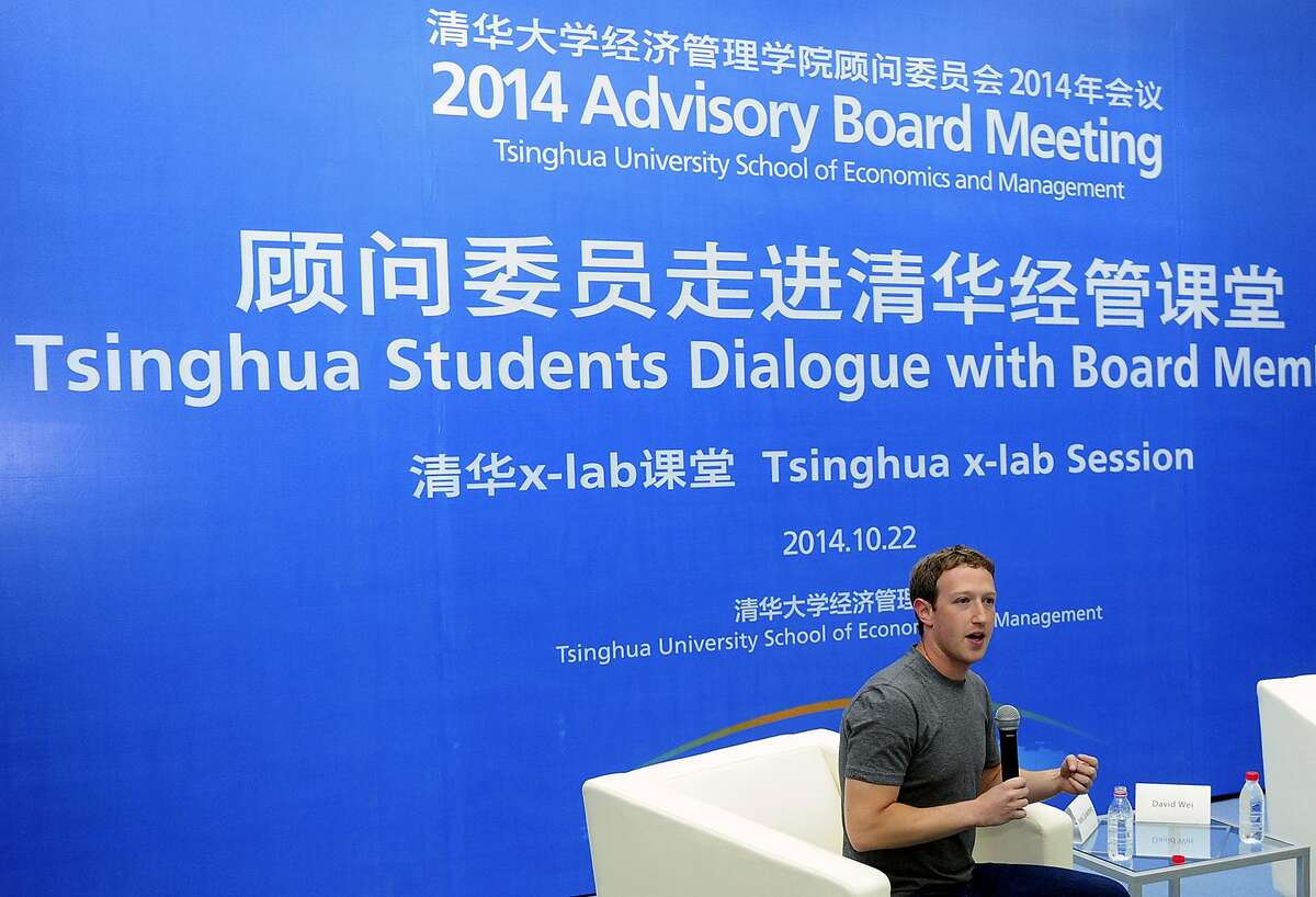 In this Oct. 22, 2014 photo released by Tsinghua University, Facebook co-founder Mark Zuckerberg speaks during a dialogue with students as a newly-appointed member to the advisory board for Tsinghua University School of Economics and Management in Beijing, China. China may ban Facebook, but not its co-founder Zuckerberg, and he entertained an audience of students with a 30-minute chat in his recently learned Mandarin Chinese at the prestigious Beijing university. (AP Photo/Tsinghua University)