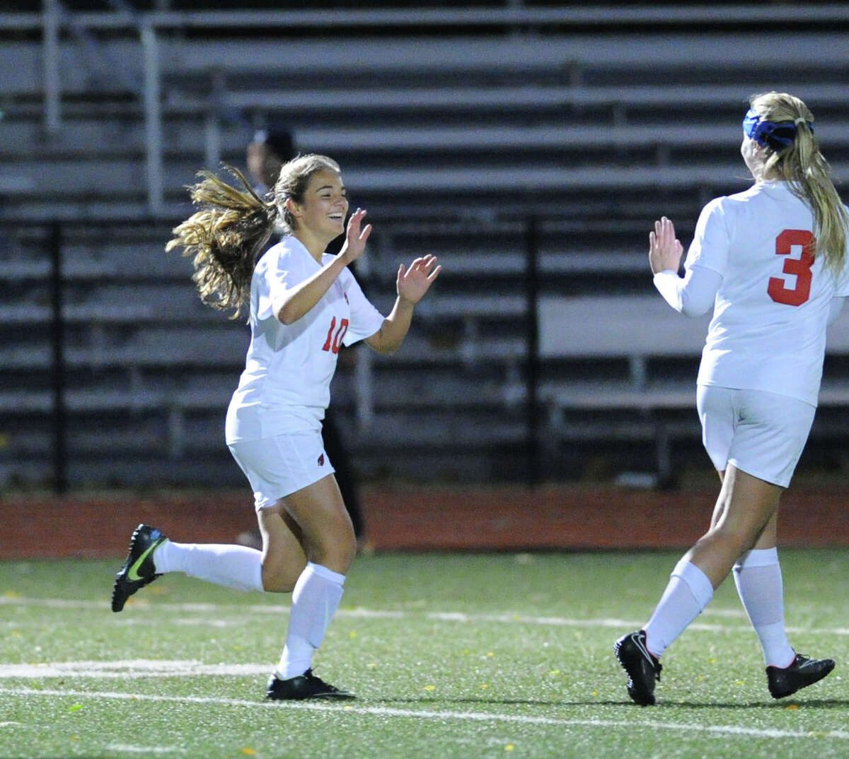 At left, Emily Berzolla (#10) of Greenwich smiles after scoring the only goal of the match during first half action of the girls high school soccer match between Greenwich High School and Trumbull High School at Greenwich, Conn., Thursday, Oct. 23, 2014. At right is Berzolla's Greenwich teammate Treloara Harrisson (#3). Greenwich won the match, 1-0.
