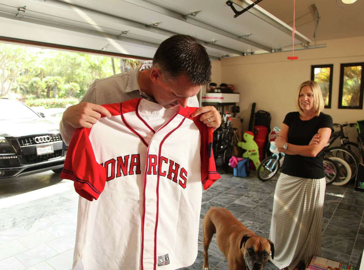A.J. Hinch, the Astros new manager, finds an old jersey from his playing days in his garage in his San Diego home with his wife Erin and dog Coco. |Photo by John Gastaldo