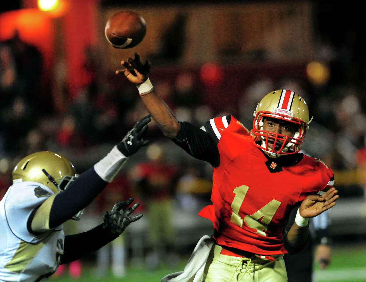 Stratford's Cristian Fidalgo throws a pass as Notre Dame of Fairfield's Hakim Fleming looks to sack, during football action in Stratford, Conn. on Friday October 24, 2014.