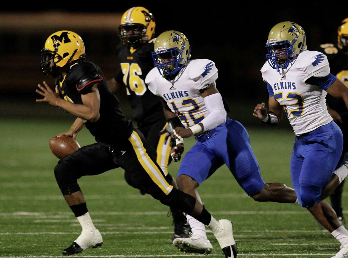 Marshall quarterback Jeremy Smith scrambles as he is pursued by Elskins' Leroy Godfrey (42) during a high school football game between Elkins and Fort Bend Marshall at Hall Stadium, Friday, Oct. 24, 2014. (Bob Levey/For The Chronicle)